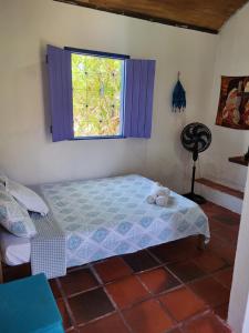 a bedroom with a bed and a window at Chalé Flor do Ser in Canoa Quebrada
