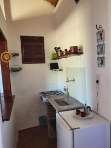 a kitchen with a sink and a counter top at Chalé Flor do Ser in Canoa Quebrada
