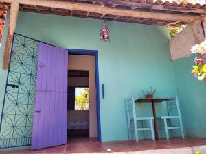 a room with a purple door and a blue wall at Chalé Flor do Ser in Canoa Quebrada