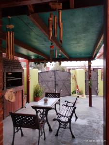 a patio with a table and chairs under a roof at Modernos departamentos PB cerca del centro y del mar in Mar de Ajó