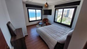 een slaapkamer met een bed en 2 grote ramen bij Tanger Luxury Family Appartments, Boulevard. in Tanger