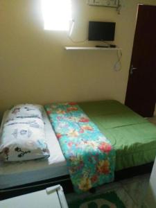 a small bedroom with a bed and a tv at POUSADA AGUAS CRISTALINAS in Maceió