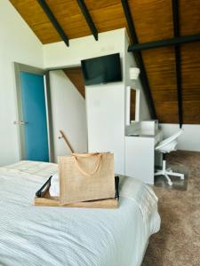 a bag sitting on a bed in a room at The Tiny Village Couple Retreat in Cabo Rojo