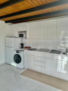a white kitchen with a washing machine in it at The Tiny Village Couple Retreat in Cabo Rojo