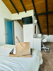 a bag sitting on top of a bed in a room at The Tiny Village Couple Retreat in Cabo Rojo