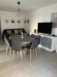 a living room with a table and chairs and a tv at Sunset House / Casa Por do Sol in Nazaré