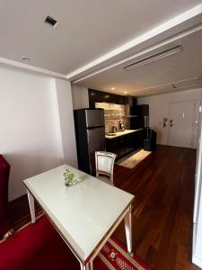 uma sala de estar com uma mesa branca e uma cozinha em Habitación exclusiva em Buenos Aires
