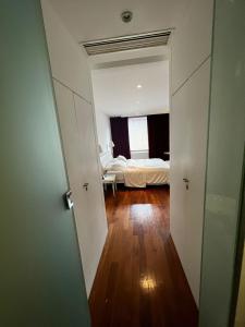 um corredor que leva a um quarto com uma cama em Habitación exclusiva em Buenos Aires