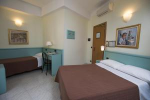 En eller flere senger på et rom på Hotel Marina