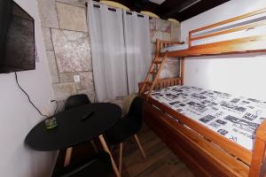una camera con letto a castello, tavolo e sedie di Castelinho Solemar - Hot Spa - Studios e Suítes Premiums para Locação - Auto check-in - Monitoramento remoto a Praia Grande