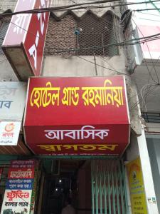 a red sign with yellow writing on the side of a store at Hotel Grand Rahmania, Central Motijheel-Dhaka in Dhaka