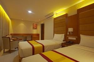 a hotel room with two beds and a desk at Hotel Grand Rahmania, Central Motijheel-Dhaka in Dhaka