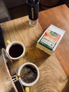 a wooden table with two cups of coffee and a bag of coffee at Hotel Casa Dulces del Jardín in Jardin +14 photos