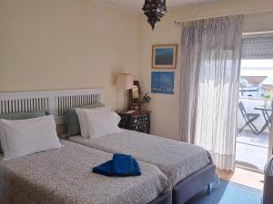 um quarto com uma cama com uma toalha azul em Friends'house - azores em Rosário-Lagoa