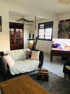 a living room with a couch and a piano at Chambre d'hôtes MAÏ TAÏ 4 personnes Bas du Fort in Le Gosier +62 photos