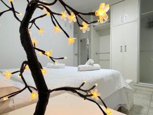 a bedroom with a bed and a tree with flowers on it at Apartamento 3 quartos e boas energias in Balneário Camboriú