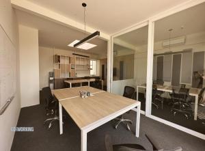 um escritório com uma grande mesa de madeira e cadeiras em 2BR Apartamento Moxie Paracas con Terraza y AC en 1r Piso em Paracas