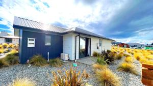 a blue and white house with plants in front of it at Number 12 Apartment in Lake Tekapo