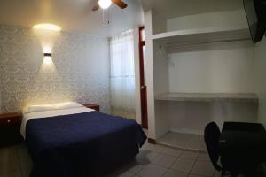 um quarto com uma cama, uma secretária e uma luz em La Posada Norteña em Lambayeque