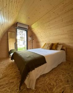 a bedroom with a large bed in a wooden room at Bungalow Madeira - Casa das Lages - Almancil - Quinta do Lago in Almancil