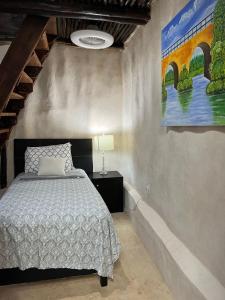 a bedroom with a bed and a painting on the wall at Cabañas Casvar in Balcheil