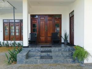 a house with wooden doors and stairs in front at The Tide's Tale in Galle
