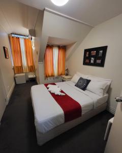 a bedroom with a bed with a cat laying on it at The Shakespeare Hotel in Auckland