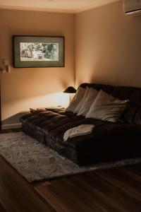 um sofá de couro preto num quarto com um candeeiro em Waterfall Lodge em Carool