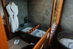 a bathroom with a black tub and a shower at Waterfall Lodge in Carool