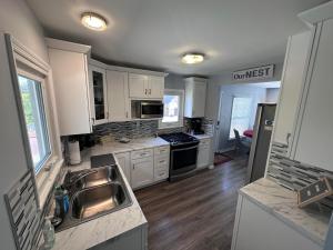 a kitchen with a sink and a stove top oven at Charming Duplex on Main in St. Charles