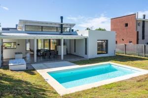 a house with a swimming pool in the yard at Perseo 1422 in Pinamar