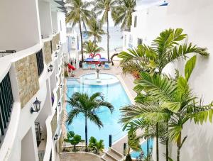 an overhead view of a swimming pool with palm trees and the ocean at Boracay Ocean Club Beach Resort in Boracay