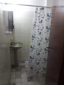 a bathroom with a shower curtain and a sink at Ayre del Tuyu in Mar del Tuyú