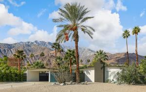 een palmboom voor een huis met bergen bij Bright & Harmonious Oasis - A Ryson Property in Palm Springs