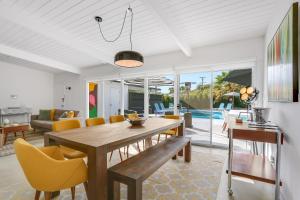 een eetkamer met een houten tafel en gele stoelen bij Bright & Harmonious Oasis - A Ryson Property in Palm Springs