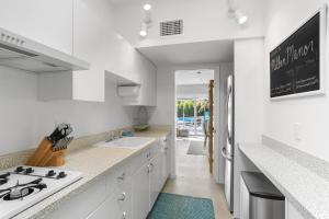 een witte keuken met een wastafel en een fornuis bij Bright & Harmonious Oasis - A Ryson Property in Palm Springs