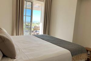 sypialnia z łóżkiem i balkonem z widokiem na okolicę w obiekcie Villa with pool and sea view with two independent floors w Faro