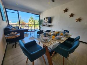 a dining room and living room with a table and chairs at OLEA Beach Condos en Chicxulub Puerto in Chicxulub
