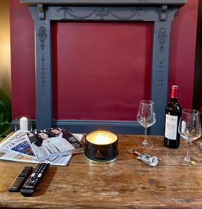 una mesa con una vela y dos copas de vino en The Bolt Hole en Stratford-upon-Avon