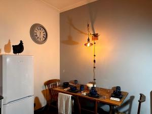 a kitchen with a table and a clock on the wall at The Bolt Hole in Stratford-upon-Avon