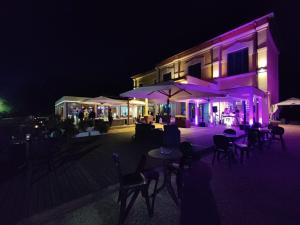 a building with tables and umbrellas at night at Hotel Antica Tabaccaia Resort in Terranuova Bracciolini