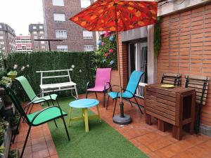 een patio met stoelen, een tafel en een parasol bij Apart 2 terrazas para 4 personas Bilbao centro in Bilbao
