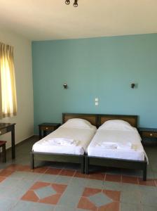 2 camas en una habitación con una pared azul en Elgini Studios, en Plakias