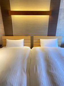 dos camas sentadas una al lado de la otra en un dormitorio en Bar 39, en Higashihiroshima