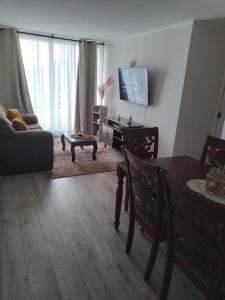 a living room with a table and a couch at Departamento nuevo en reñaca alto 2 dormitorios in Viña del Mar