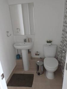 a white bathroom with a toilet and a sink at Departamento nuevo en reñaca alto 2 dormitorios in Viña del Mar
