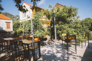 a patio with tables and chairs in front of a building at Trang An Central Homestay in Ninh Binh