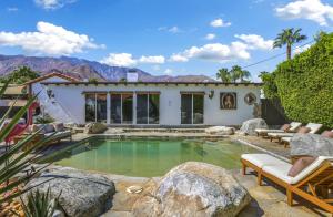 uma piscina com pedras em frente a uma casa em Casa Rosa - A Ryson Property em Palm Springs