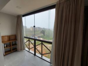 a room with a large window with a view at Apartamento sonhos da serra bananeiras in Bananeiras