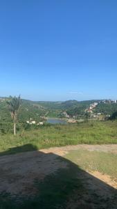 a view of a field with a tree and a lake at Apartamento sonhos da serra bananeiras in Bananeiras